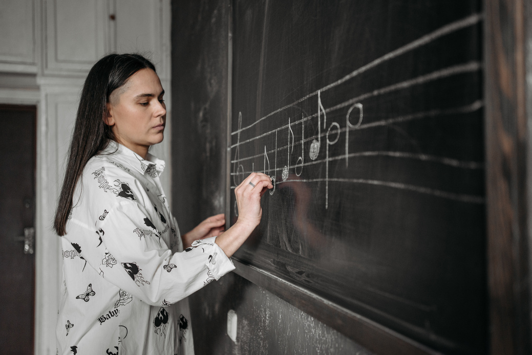 Woman Writing Musical Notation on the Blackboard
